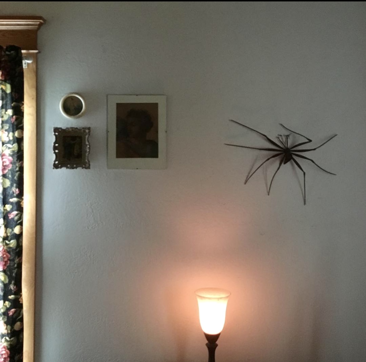 Linda's house: a floral curtain, soft pink lighting and a metal spider on the wall